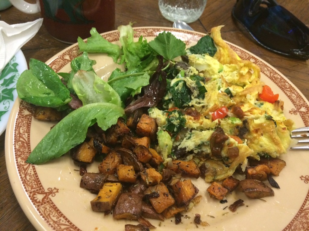 Veggie omelet with sweet potato home fries and a salad.