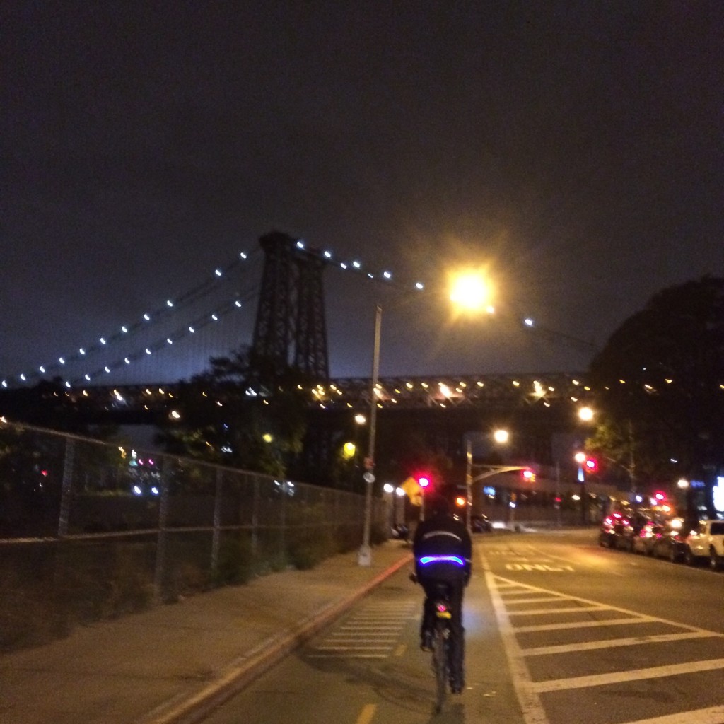 On the way home, Manhattan glows beyond the Williamsburg Bridge.